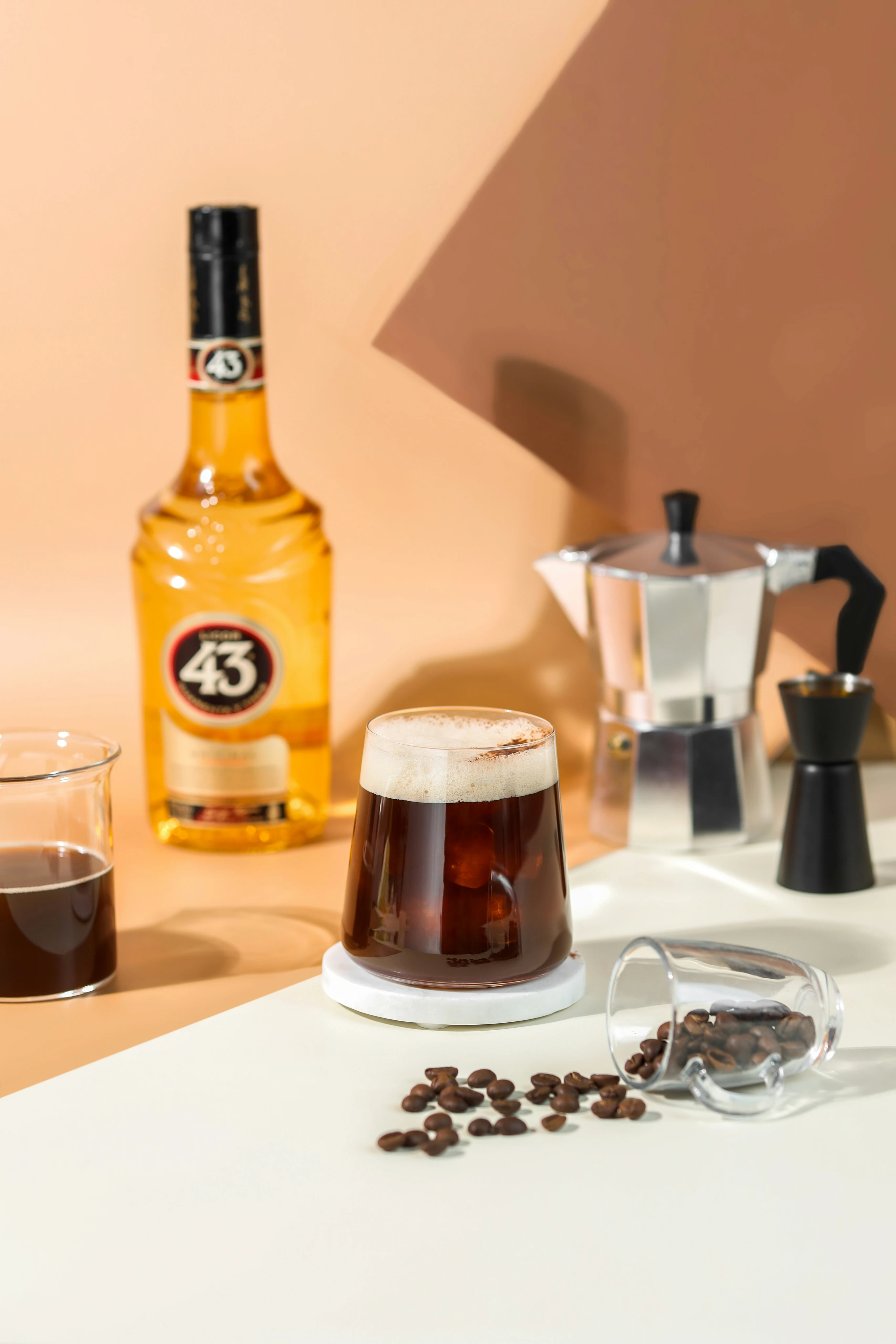 A carajillo cocktail with Licor 43, moka pot, and coffee beans